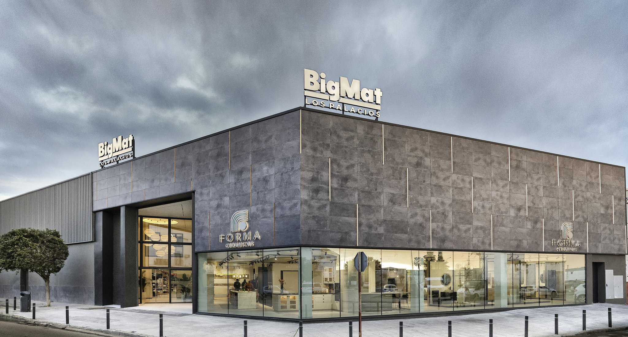 Fachada del edificio de Forma Cerámicas con rótulo BigMat Los Palacios